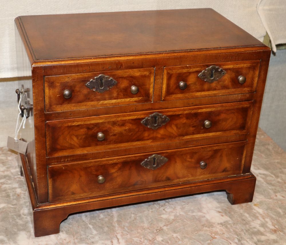 A Georgian style miniature feather banded walnut chest of drawers, W.39cm, D.21cm, H.30cm